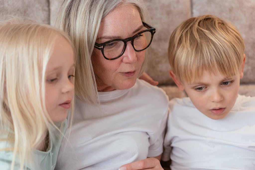 Una abuela con sus nietos, mirando algo.